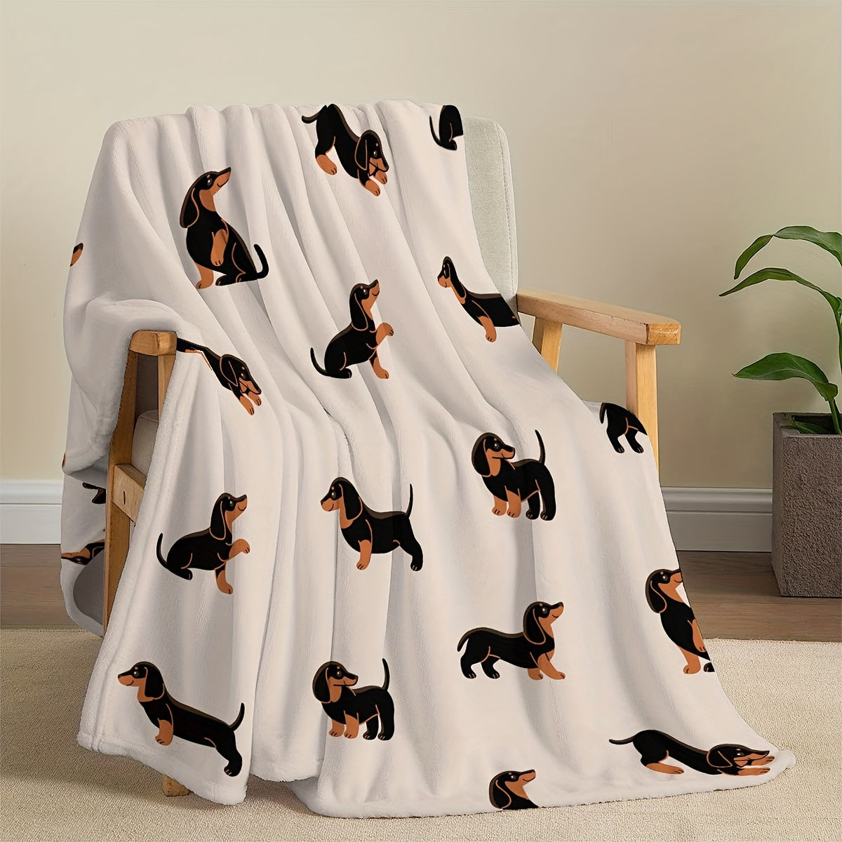 White blanket with dachshund pattern draped over a chair in a room.
