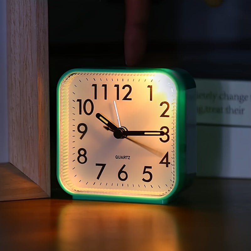 Square clock with green frame on a wooden surface