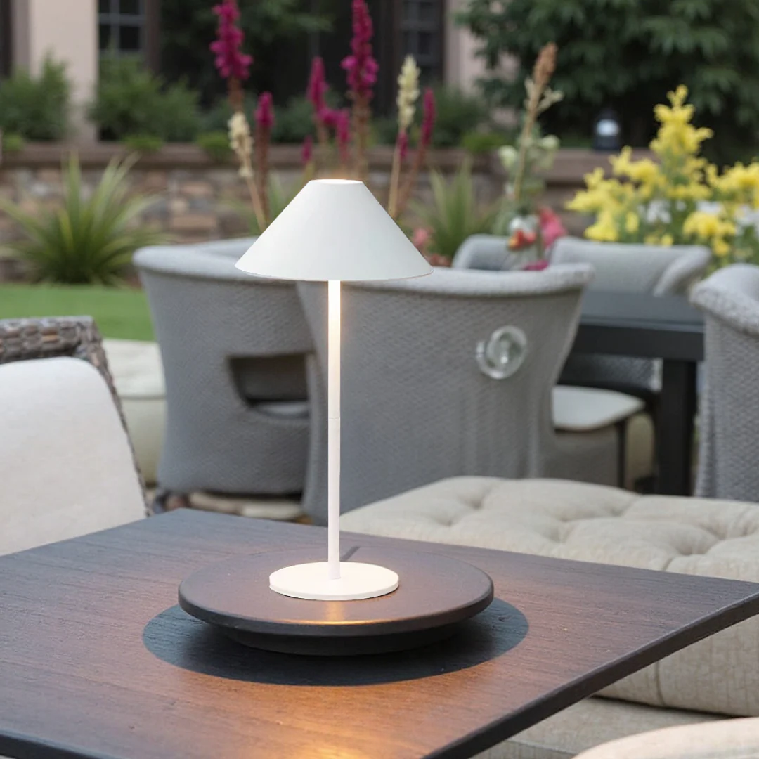 Table lamp on a table with outdoor furniture and garden in the background