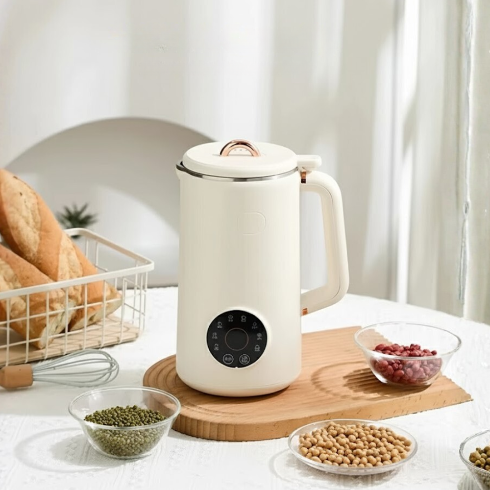 White electric milk maker on a kitchen counter with ingredients around