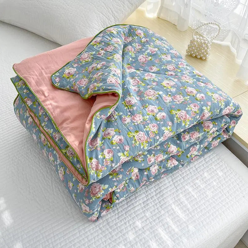 Floral-patterned quilt with pink inner lining on a bed