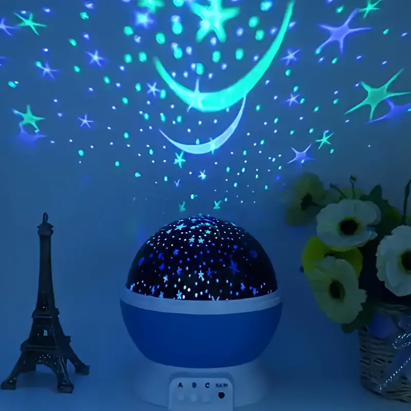 Starry night light projector with colorful star and moon patterns on a dark blue wall.