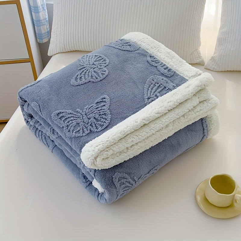 Folded blue blanket with butterfly patterns on a white surface