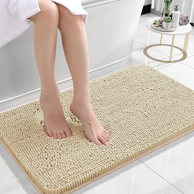Person stepping onto a beige bath mat in a bathroom setting.