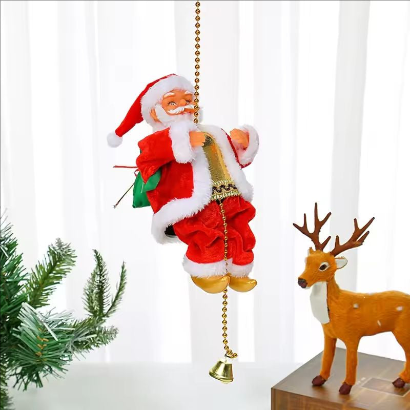 Decorative Santa Claus figure with a bell and green bag, next to a deer figurine and Christmas tree.