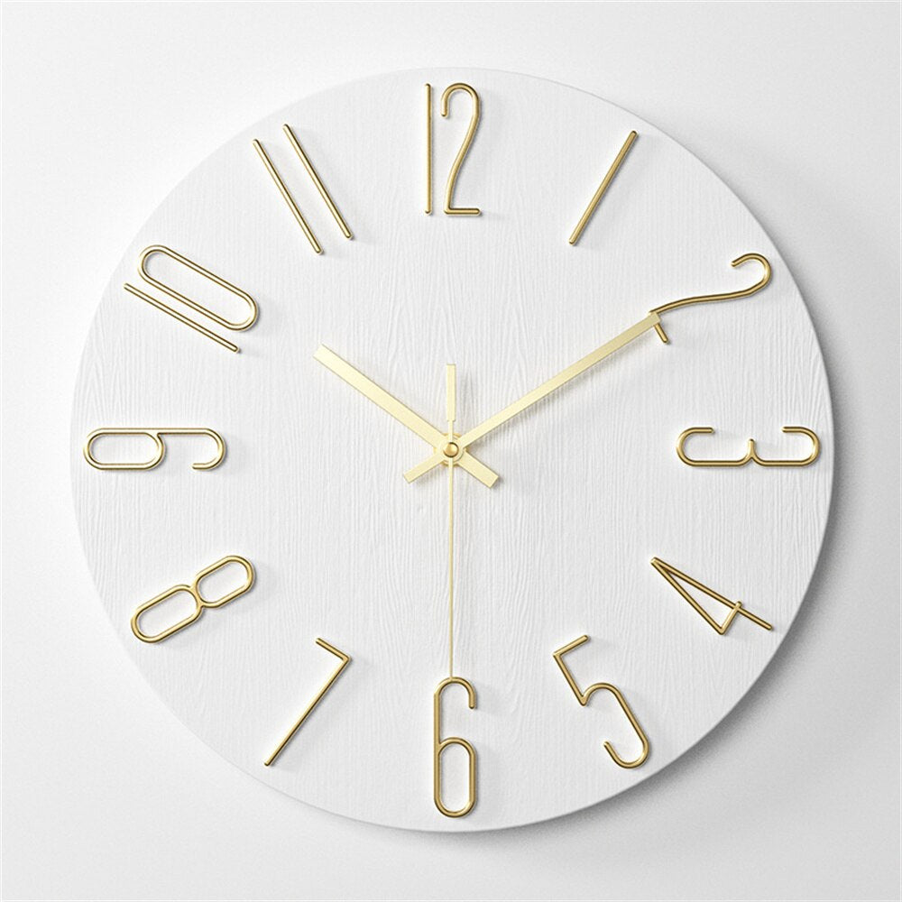 White wall clock with gold numbers and hands on a light gray background
