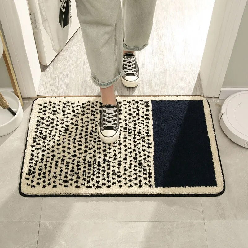 Person stepping onto a black and white patterned doormat with a blue accent.