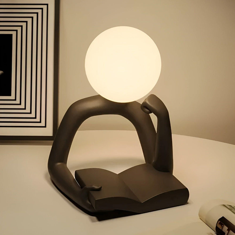 Modern table lamp with a round white shade on a dark brown base, placed on a surface.