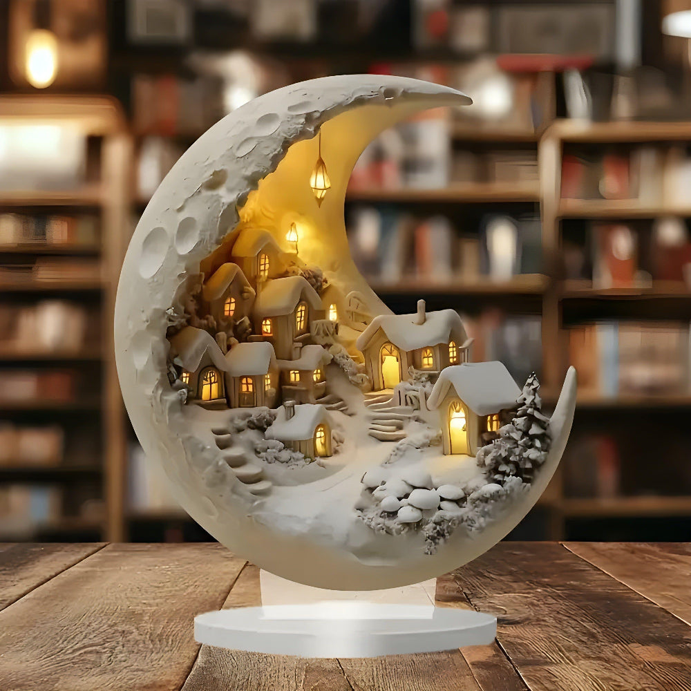 Decorative moon lamp with a snowy village scene on a wooden table.