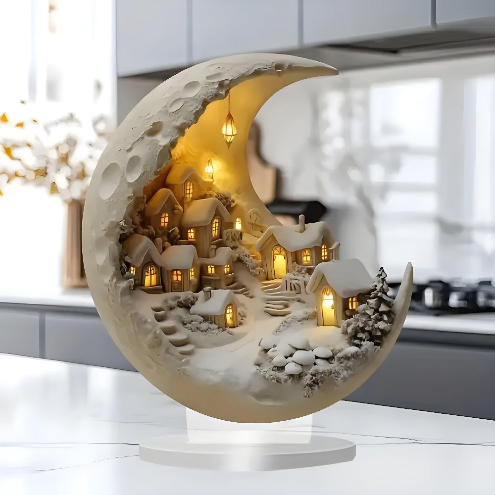 Decorative moon-shaped lamp with a small village scene inside, placed on a surface.