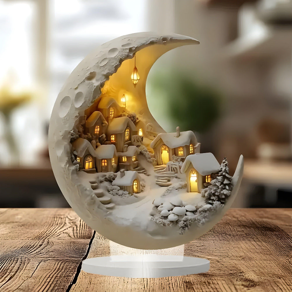 Decorative moon lamp with a small village scene inside, on a wooden surface.