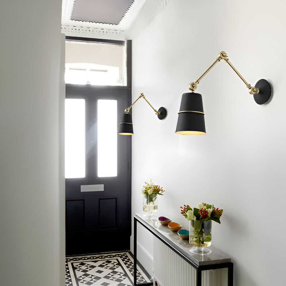 Modern wall lights in a stylish interior setting with a black door and decorative table.