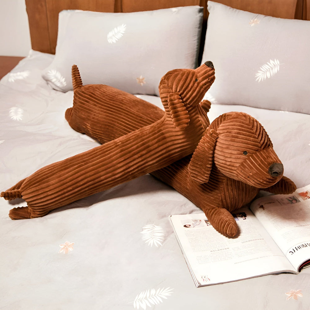 Brown plush dog toy on a bed with an open book