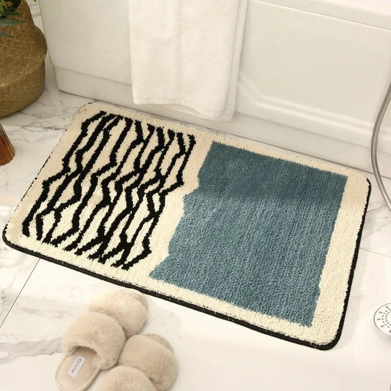 Multicolored bath mat with zebra pattern and blue square on a bathroom floor.