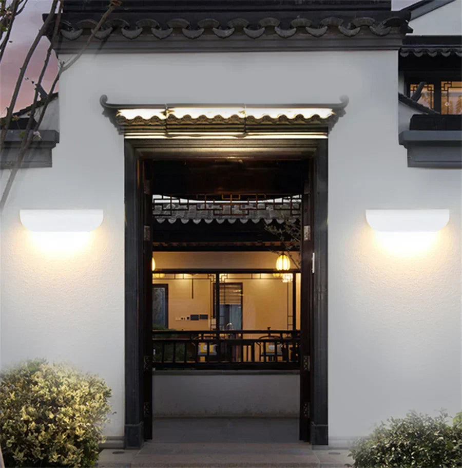 Traditional Chinese architectural entrance with white walls and dark wooden doors.