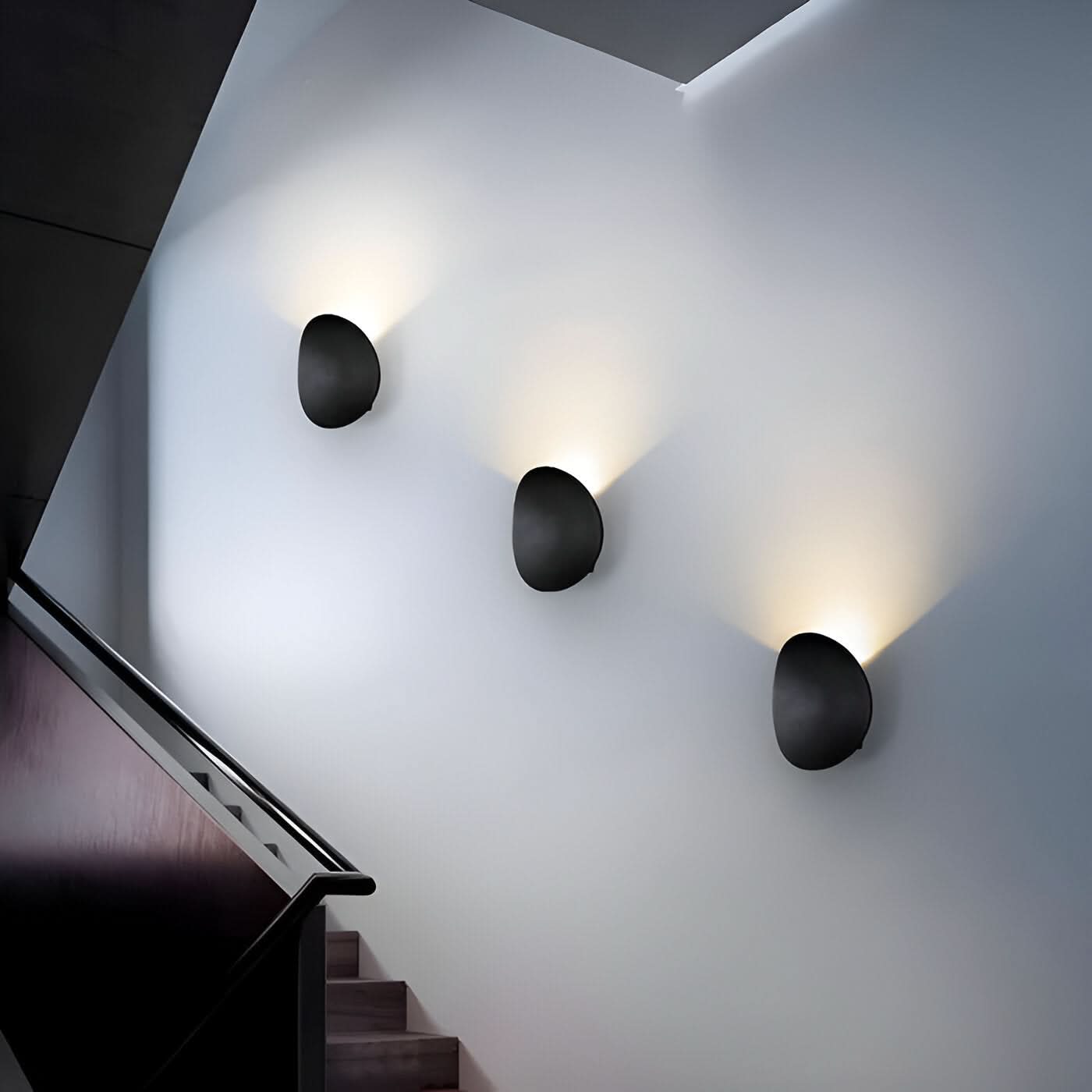 Modern wall lights on a white wall with a staircase in the foreground