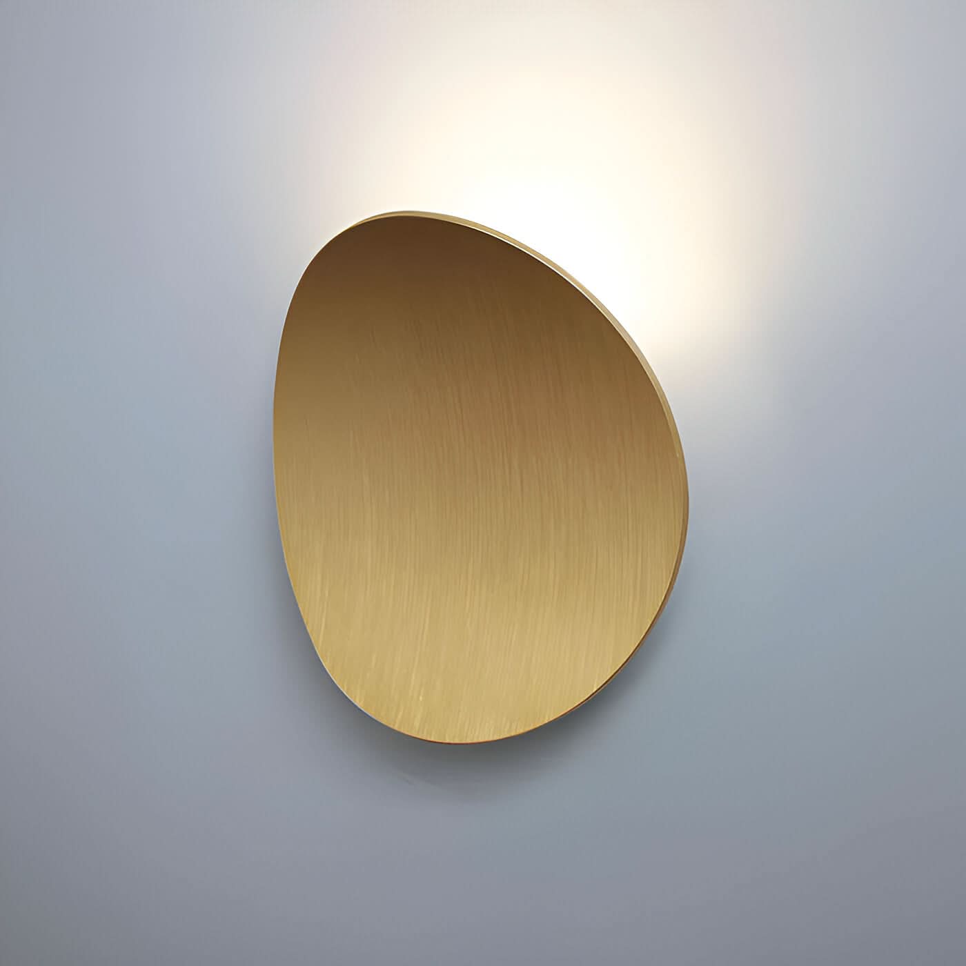 Gold wall-mounted light fixture on a gray background