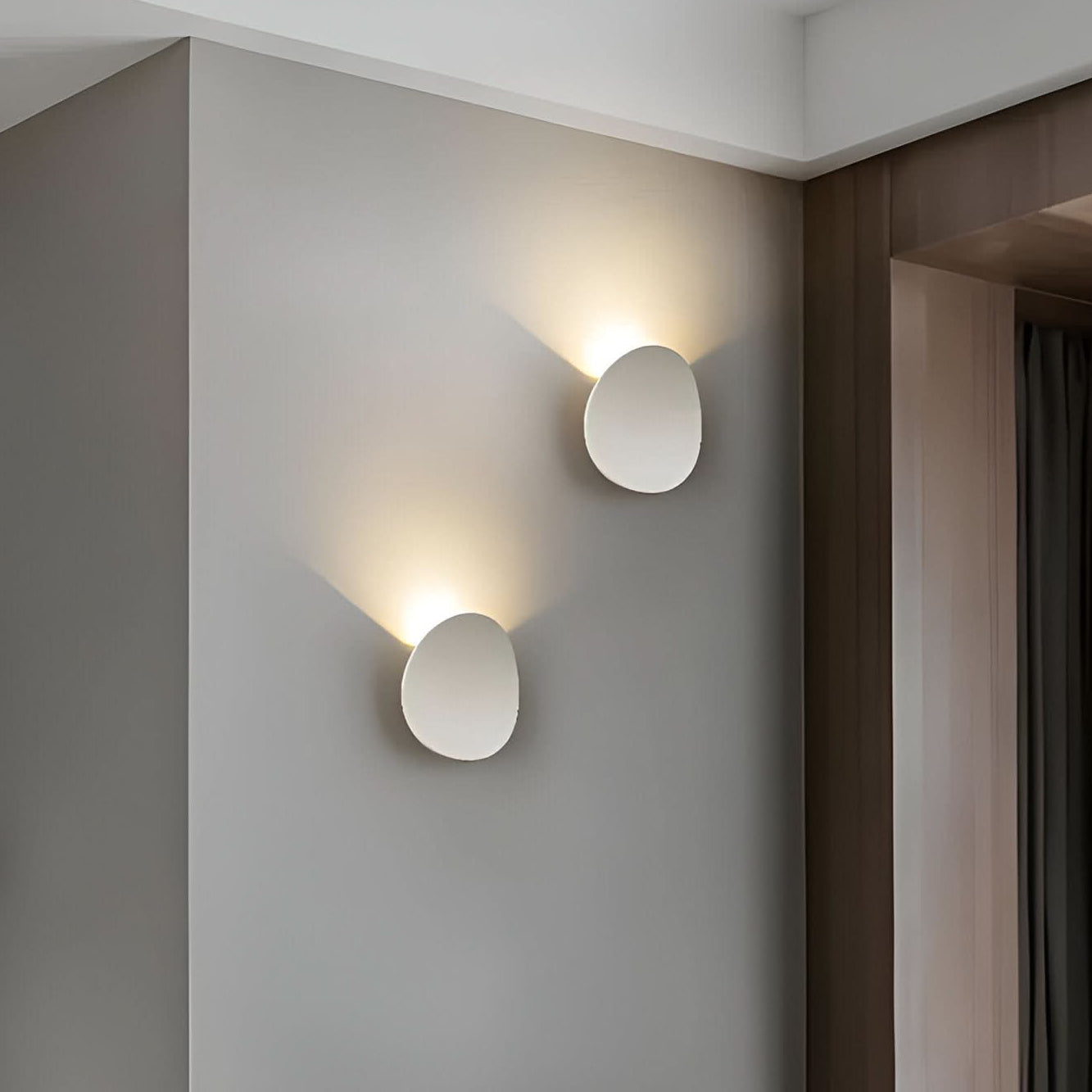 Two round wall lights on a gray wall with a neutral background