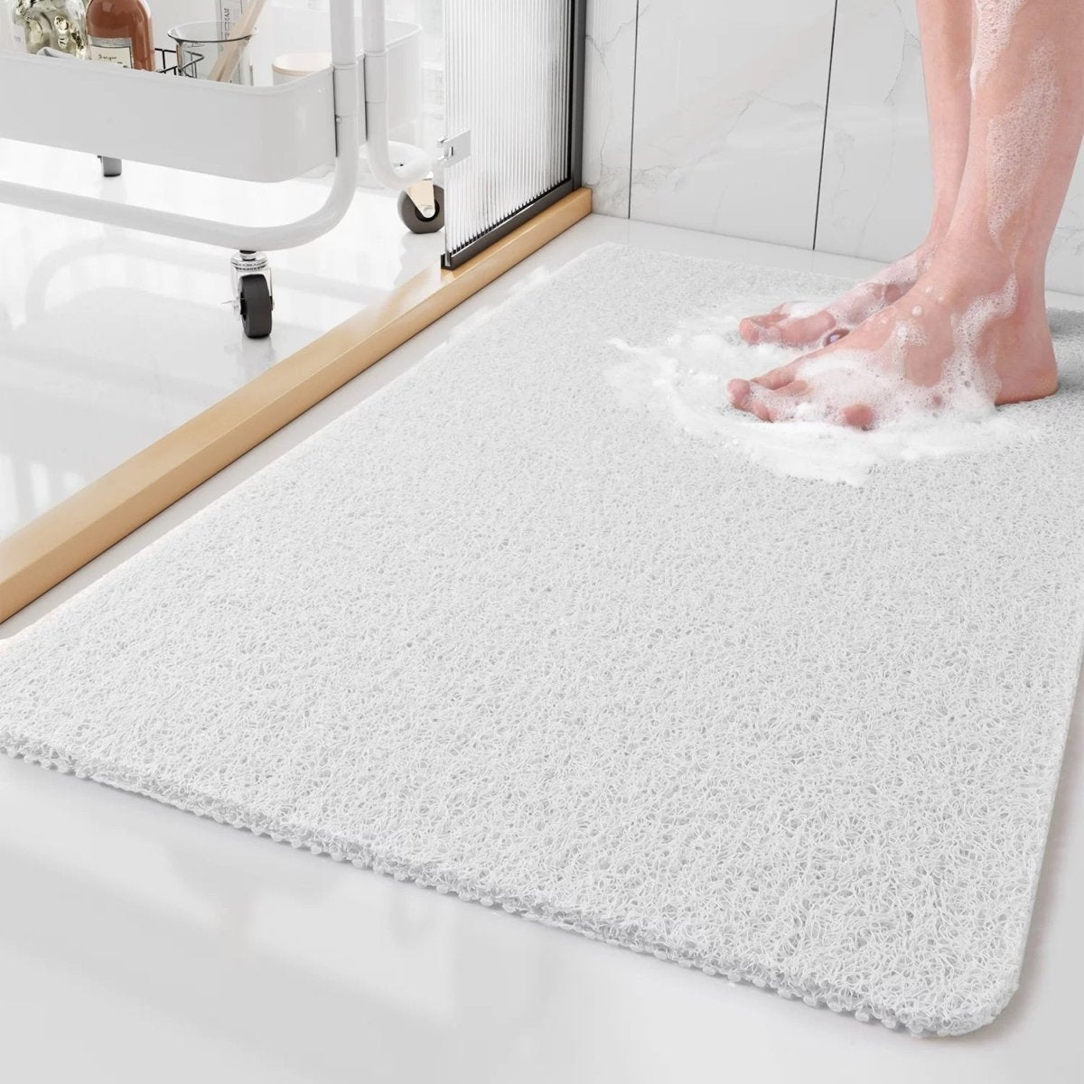 Person stepping onto a textured bath mat with soapy feet in a bathroom setting.