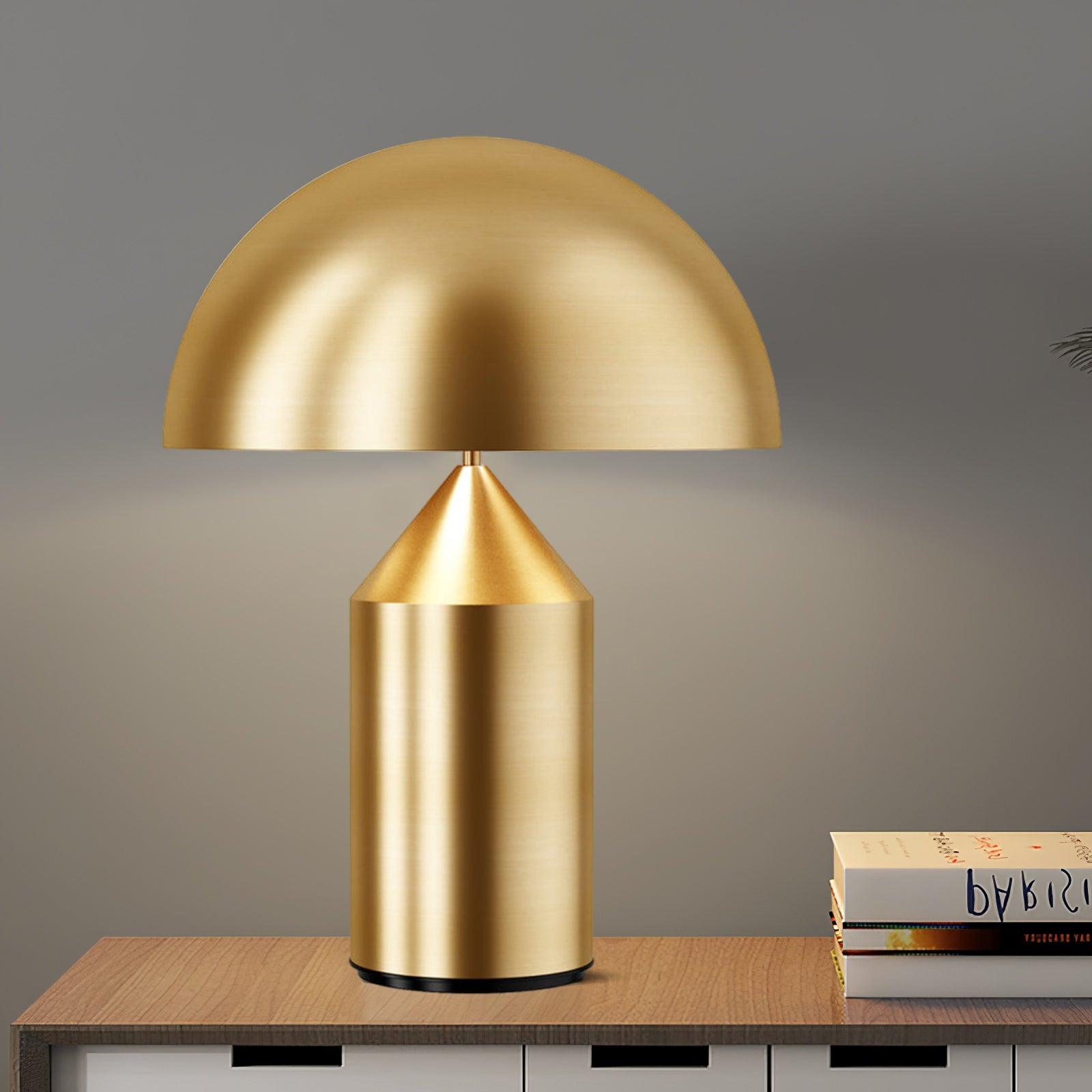 Gold table lamp on a wooden surface with a gray background