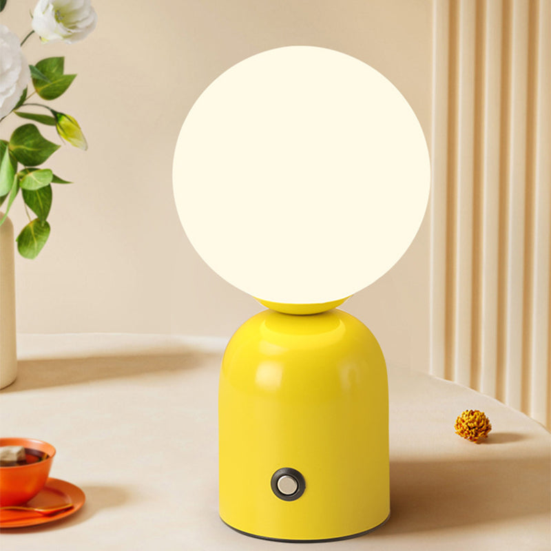 Yellow table lamp with a white globe shade on a neutral background