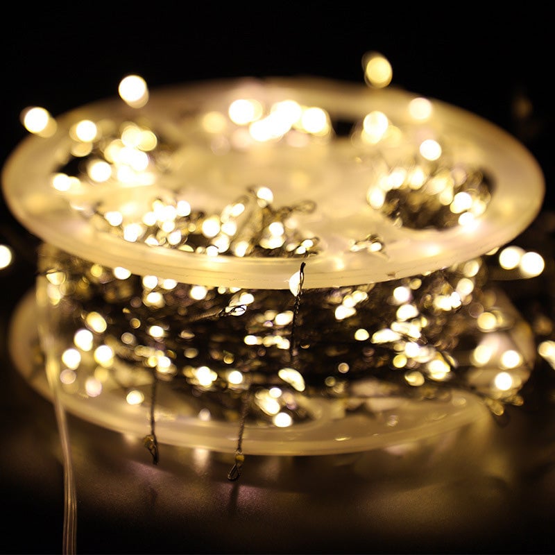 Roll of string lights with a warm glow on a dark background