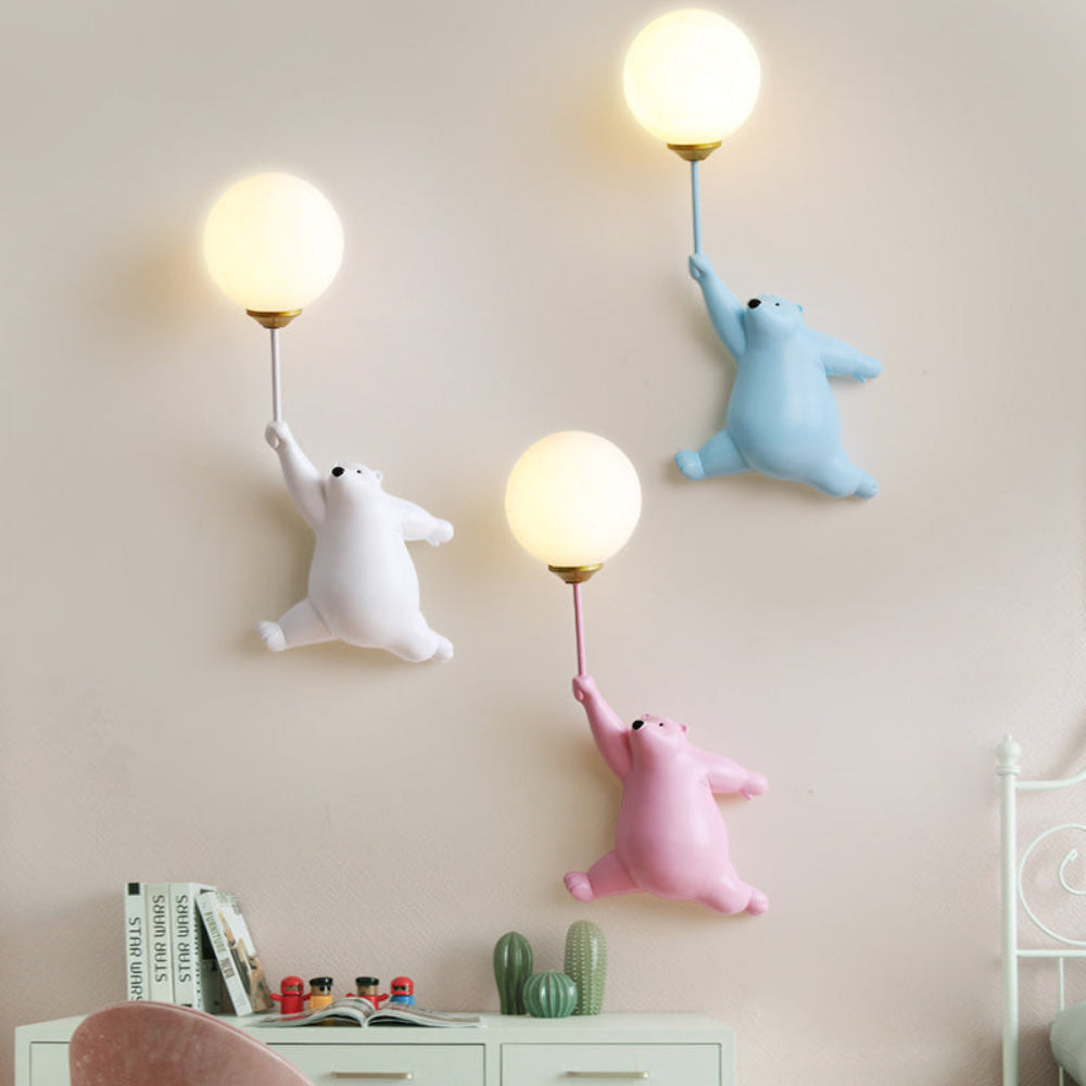 Three cartoon bear-shaped lamps hanging on a wall with a light pink background.