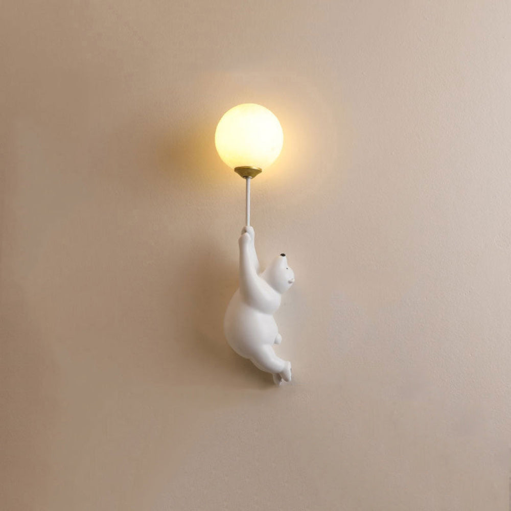 Wall-mounted light fixture with a polar bear design on a beige wall.