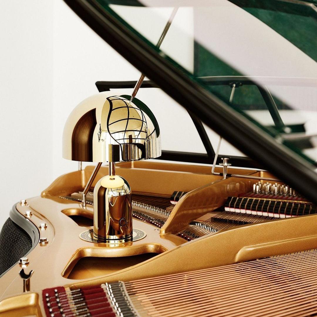 Close-up of a gold lamp on a grand piano