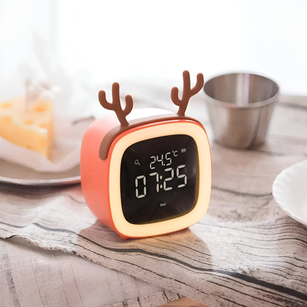 Digital clock with reindeer design on a wooden surface