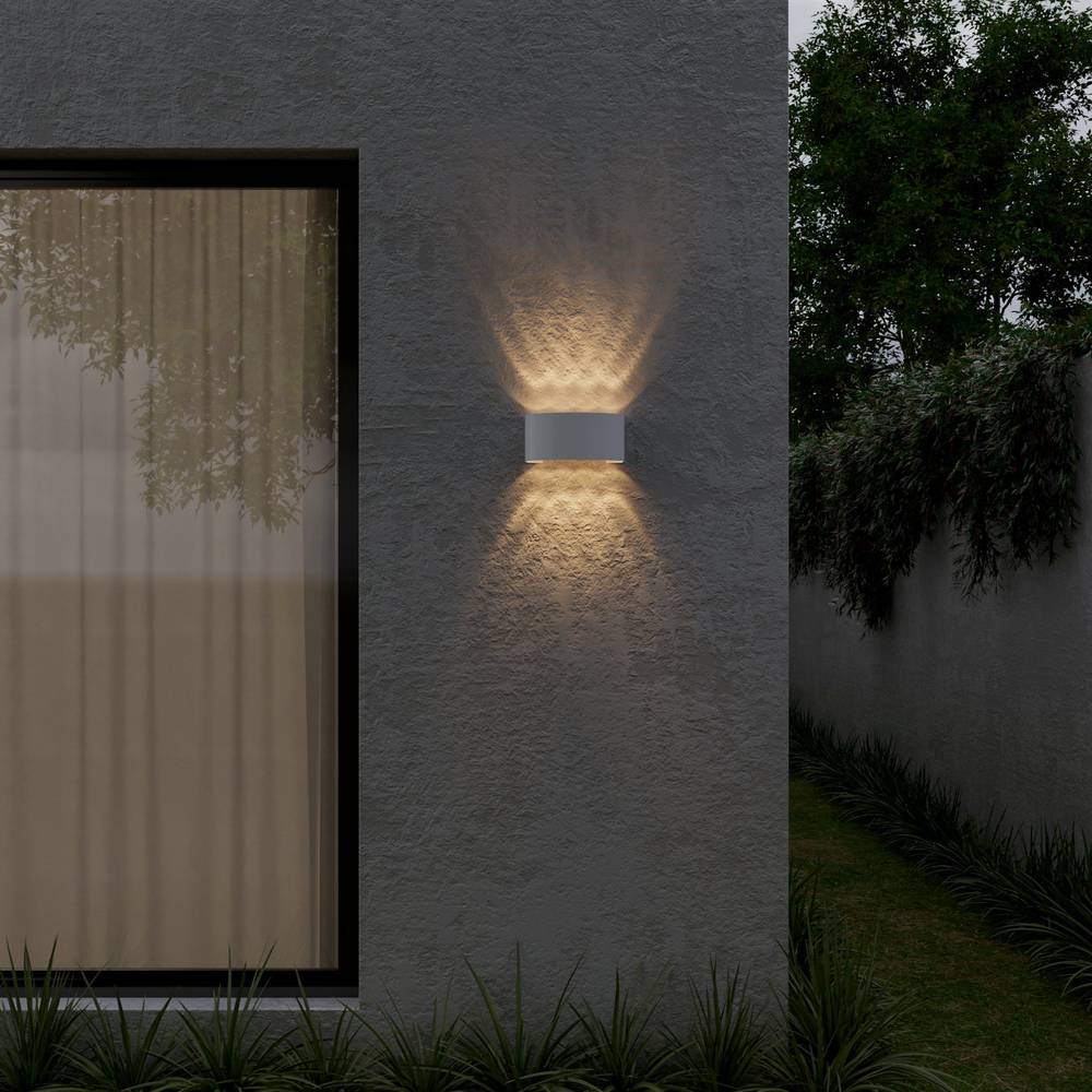 Modern outdoor wall light fixture on a textured wall with garden view