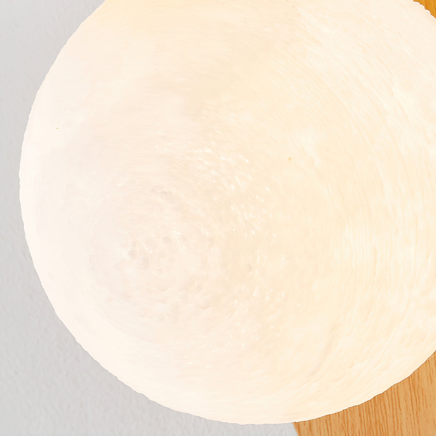 Round light fixture on a gray and wooden surface
