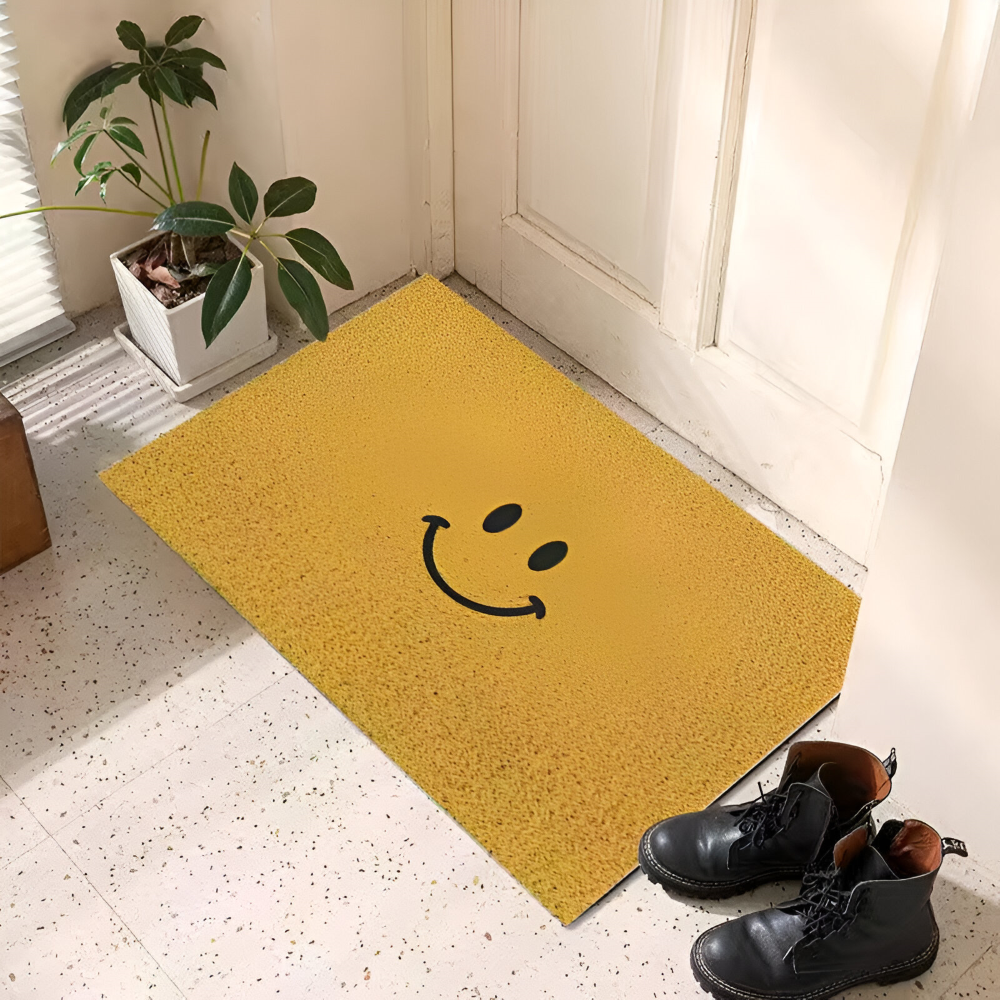 Yellow doormat with a smiley face design on a light-colored floor.