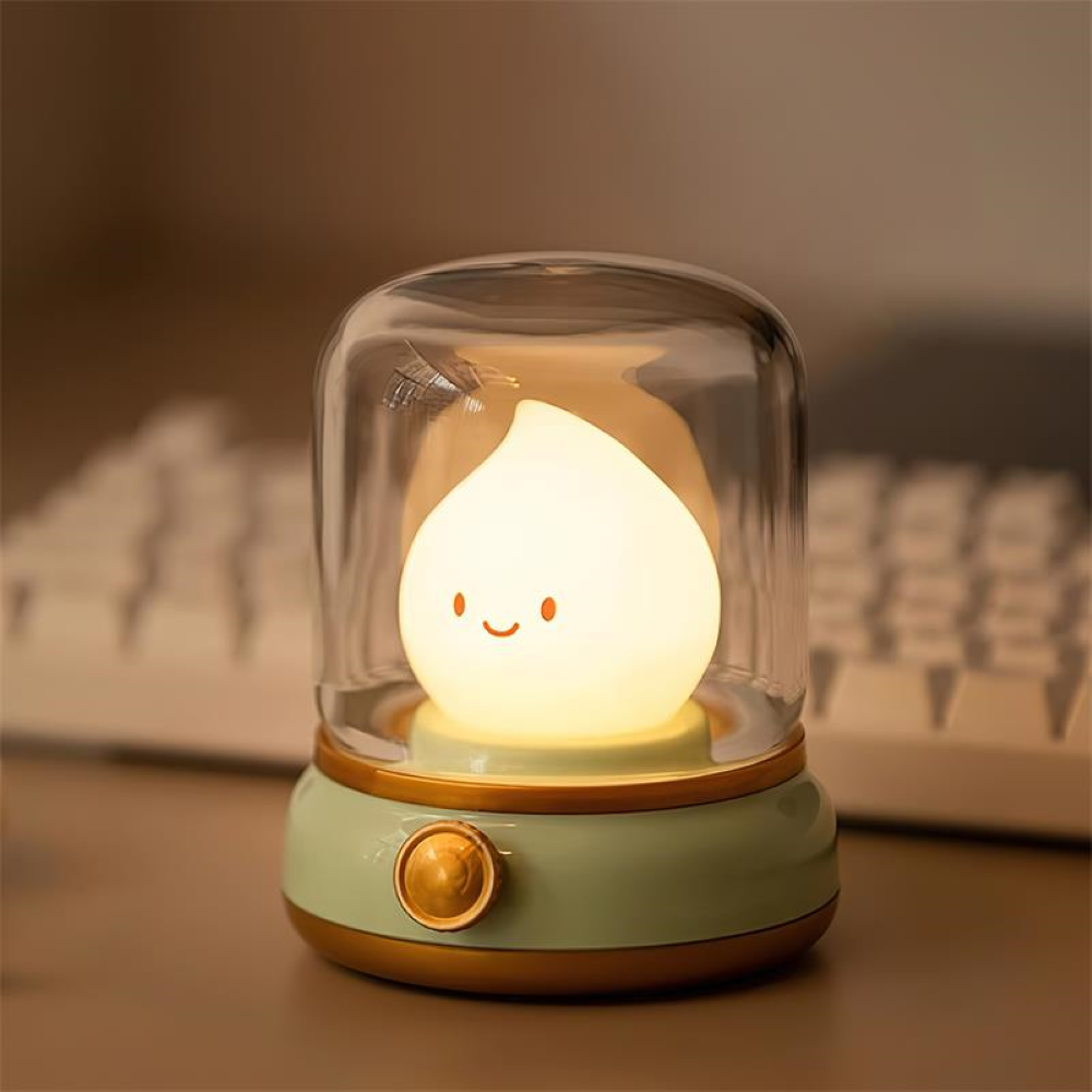 Cute night light with a smiling face inside a glass dome on a desk.