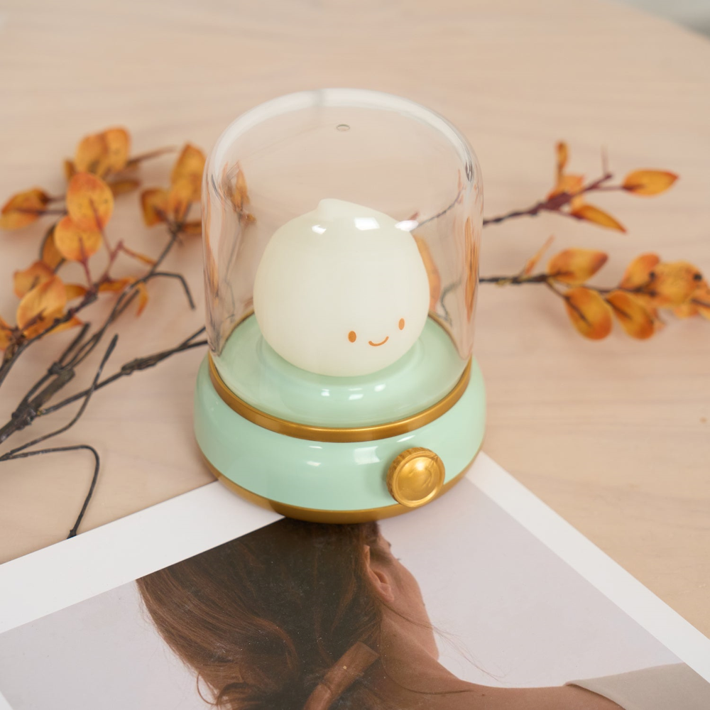 Decorative lamp with a smiling face on a table with autumn leaves