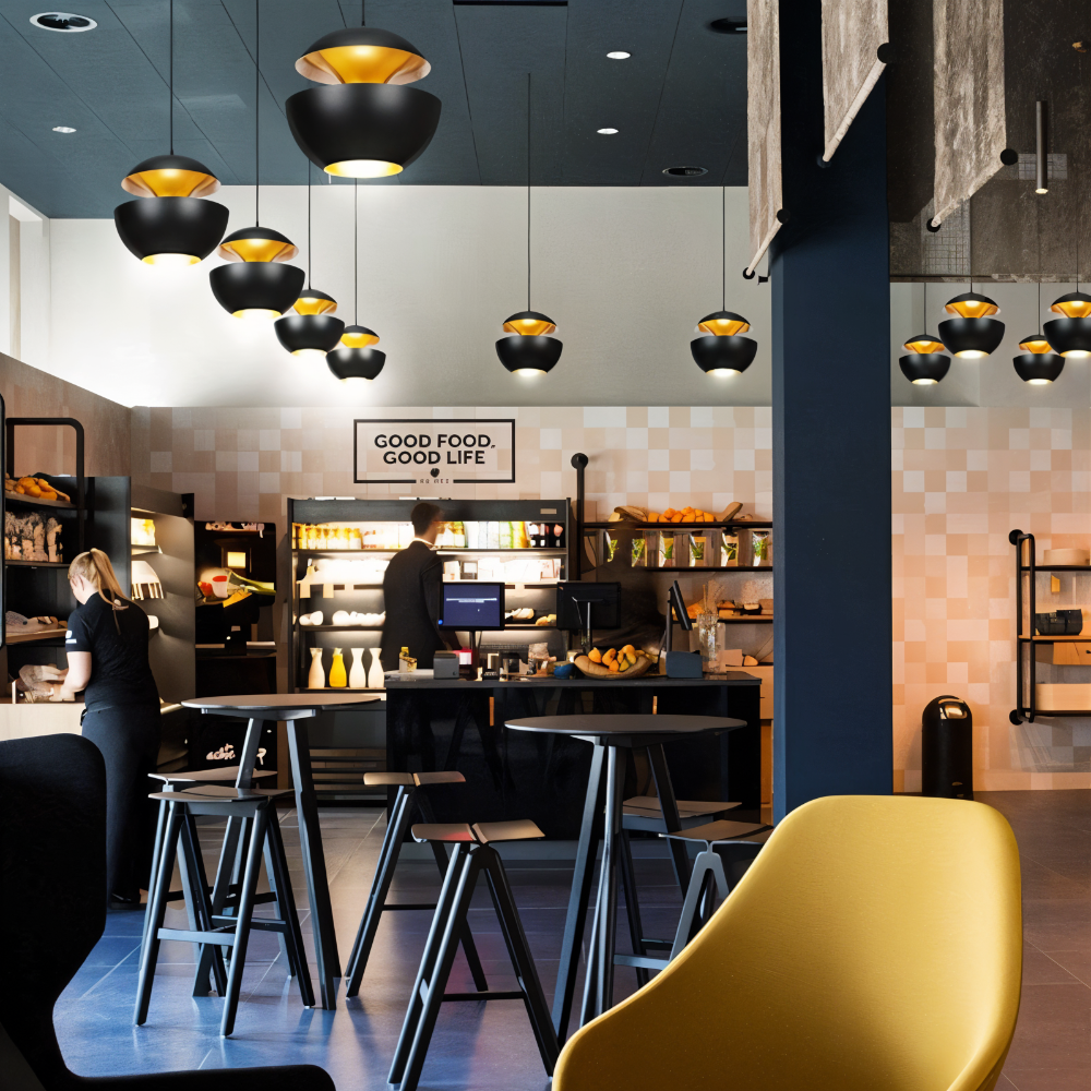 Modern restaurant interior with tables, chairs, and a 'Good Food, Good Life' sign.
