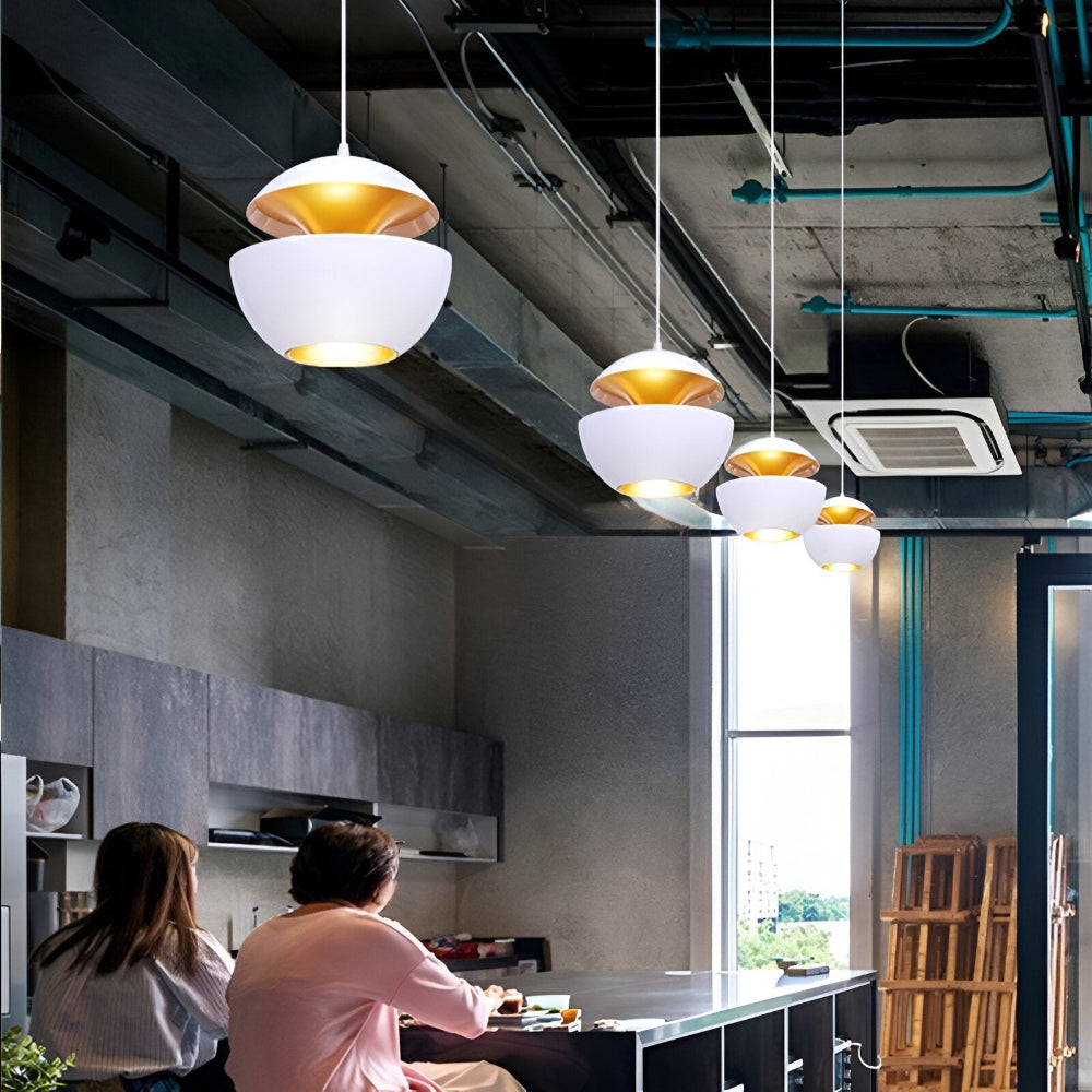 Modern kitchen interior with pendant lights and people sitting at a table.