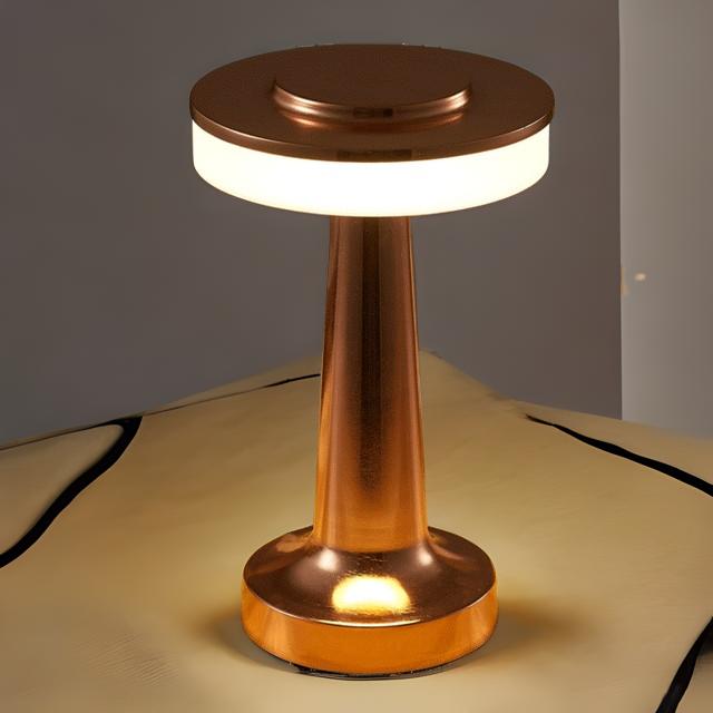 Copper-colored table lamp on a beige surface with a neutral background