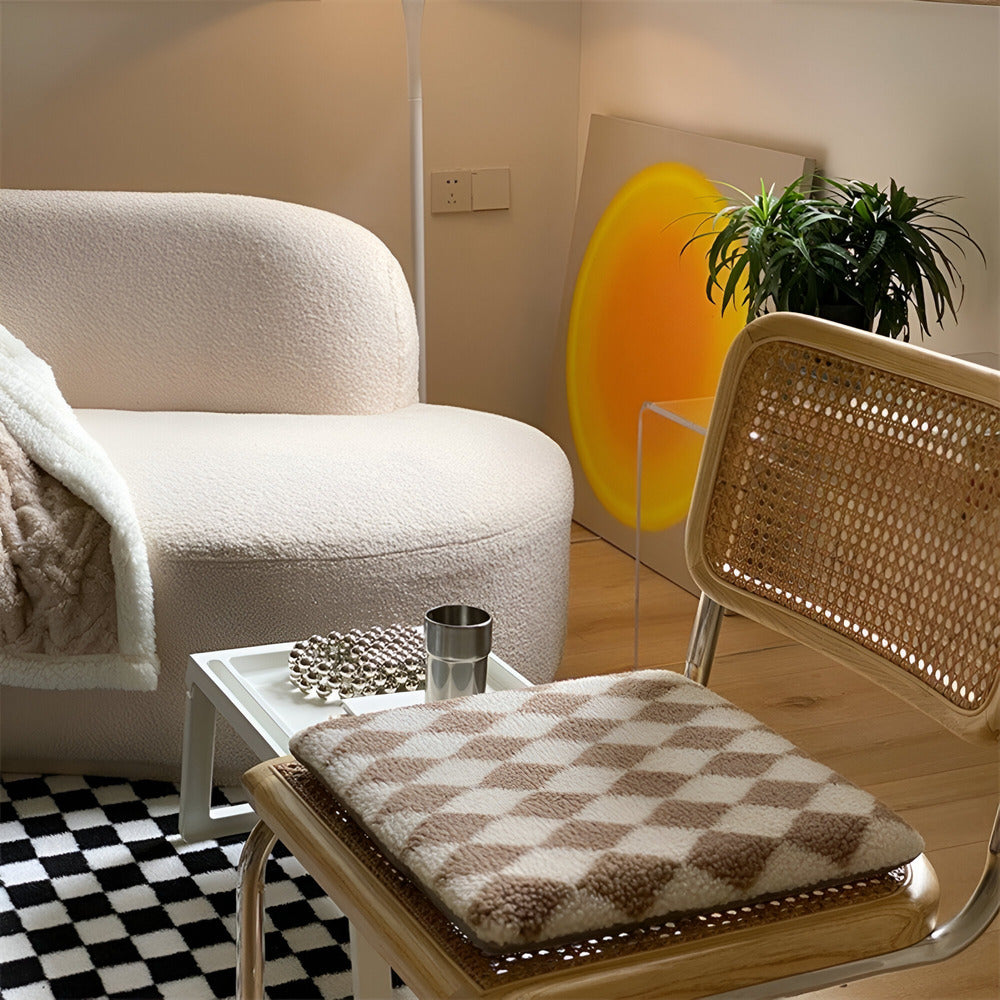 Living room with a white sofa, wicker chair, and checkered cushion.