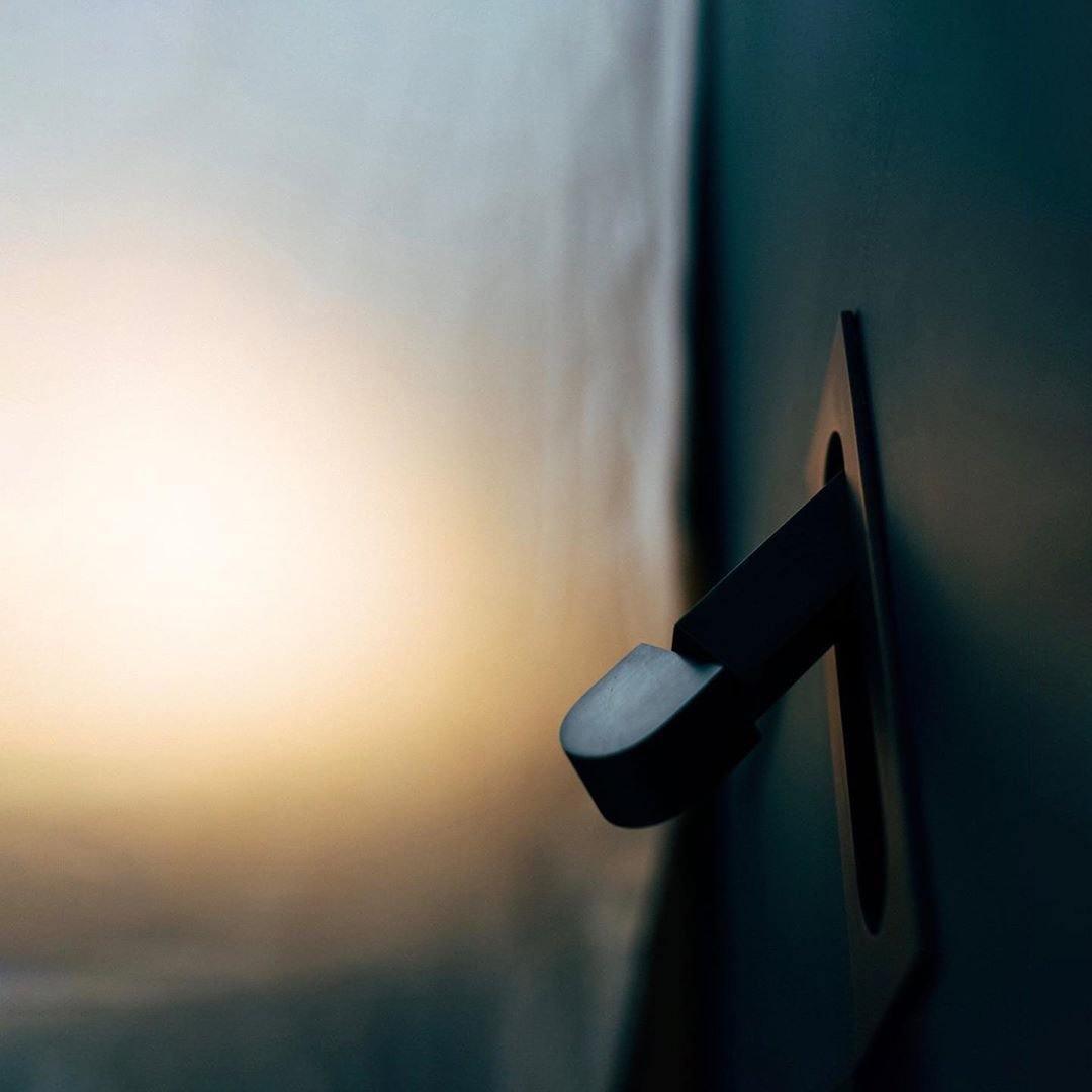 Close-up of a black door handle on a door with a blurred background