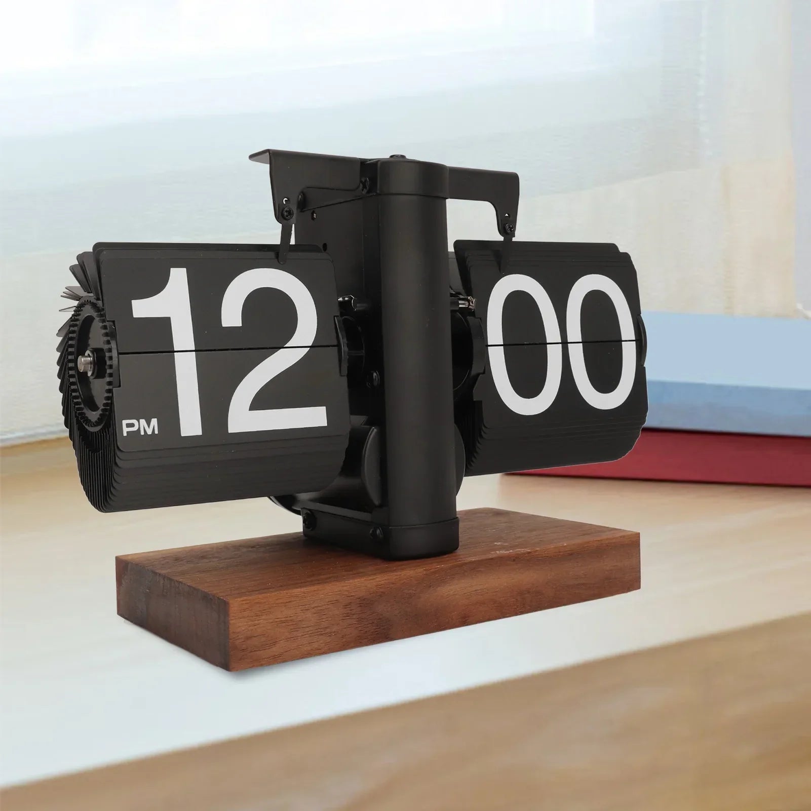 Black flip clock with wooden base on a light background