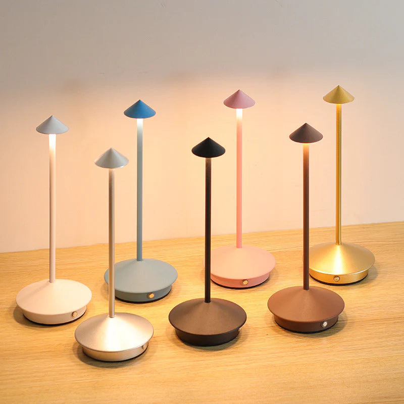 Set of colorful desk lamps on a wooden surface with a neutral background