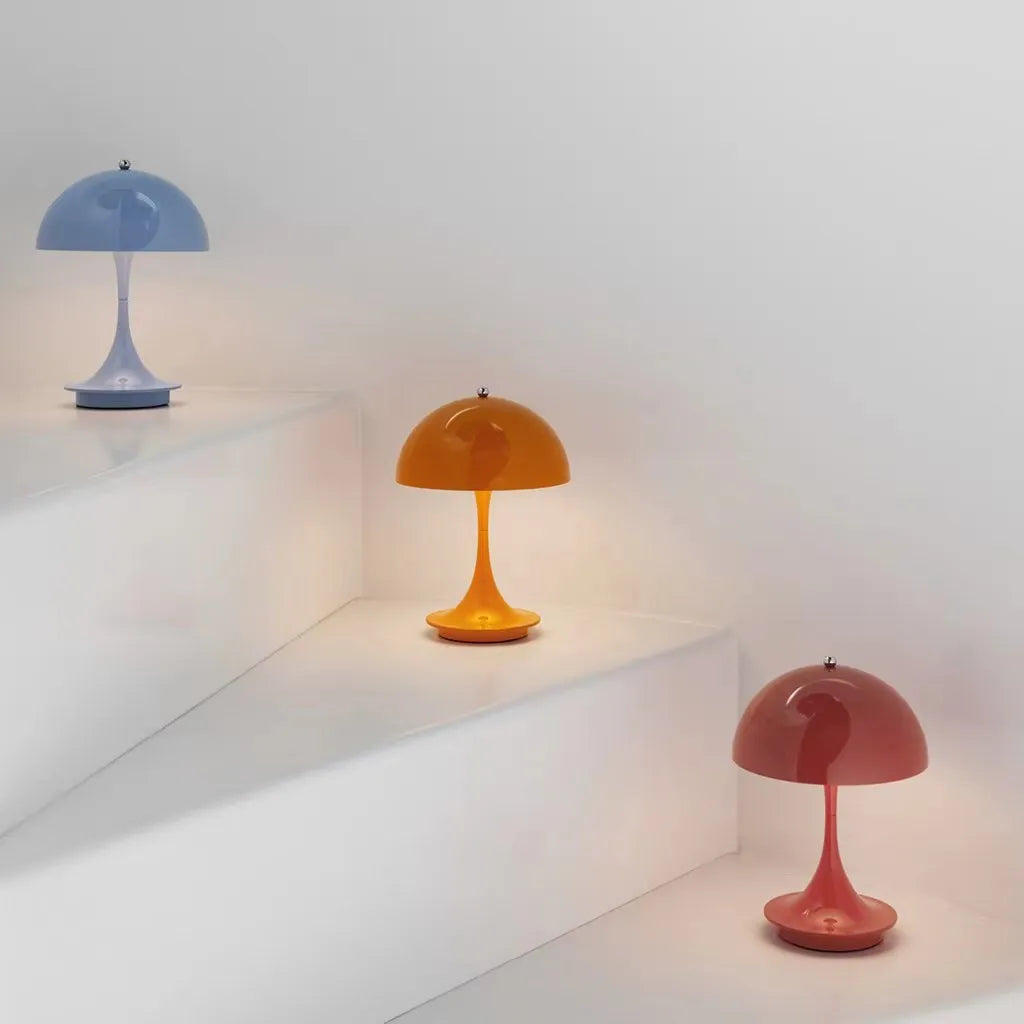 Three colorful table lamps on a white shelf with a white background