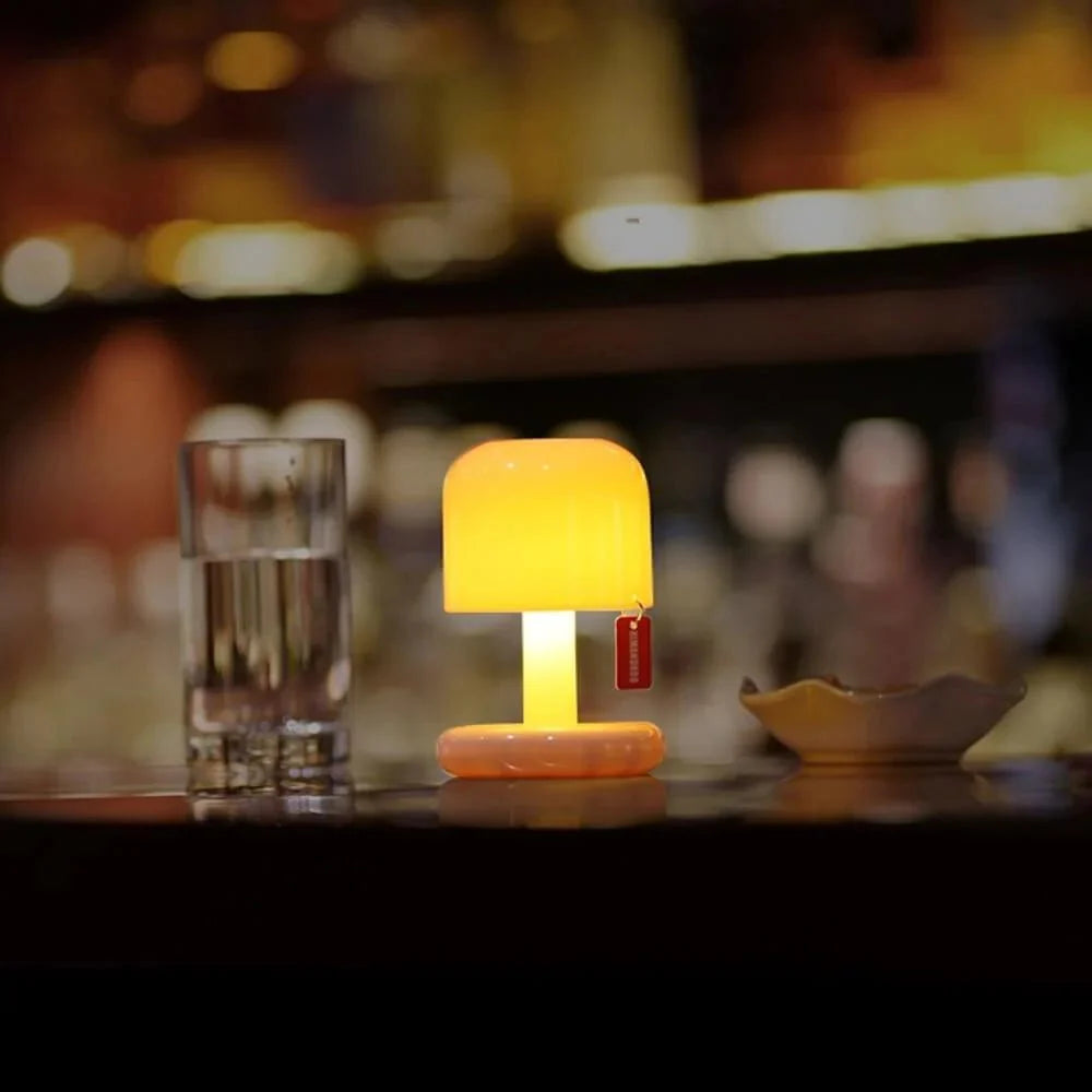 Small orange lamp on a bar counter with a blurred bar background