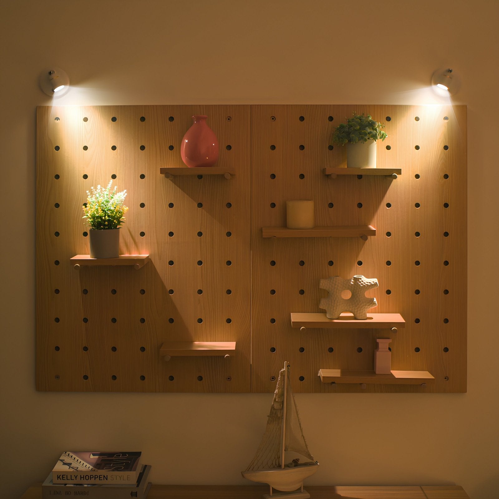 Wooden pegboard wall with shelves holding decorative items and lights on a wall.