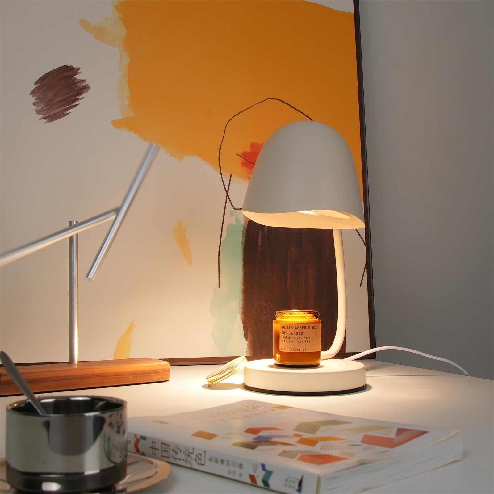 Table lamp on a desk with a candle and books, warm lighting