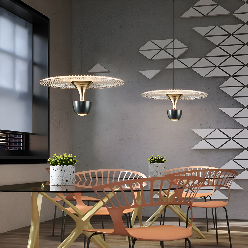 Modern dining room with gold pendant lights, glass table, and geometric wall design.