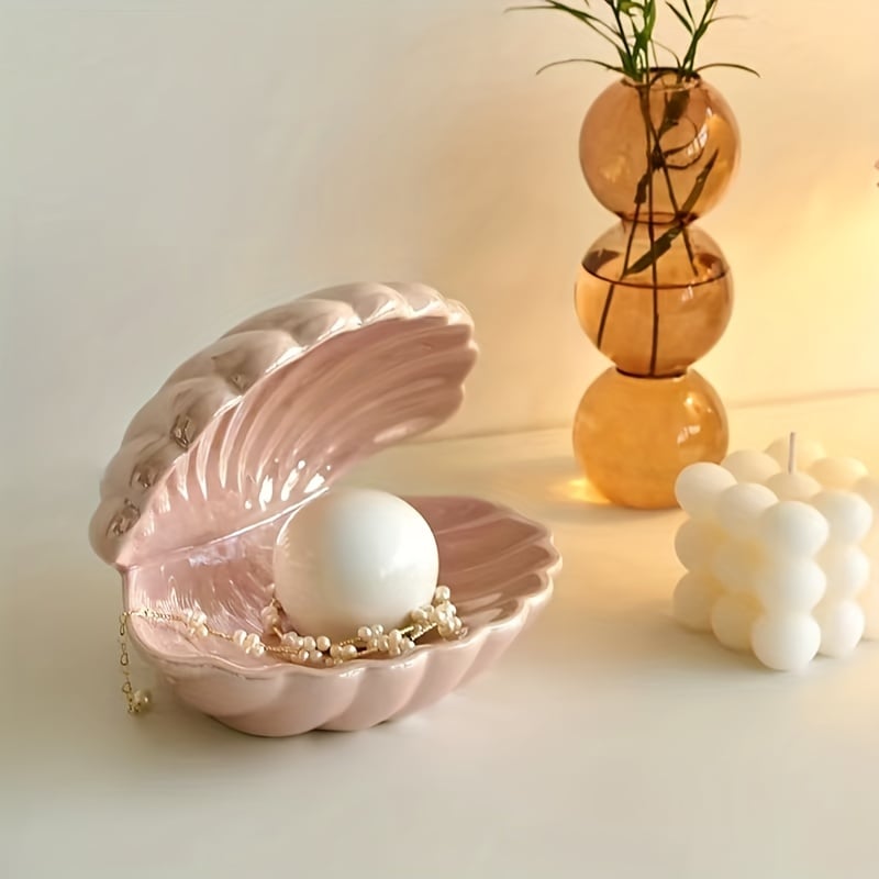 Pink shell jewelry box with a pearl and necklace on a light background