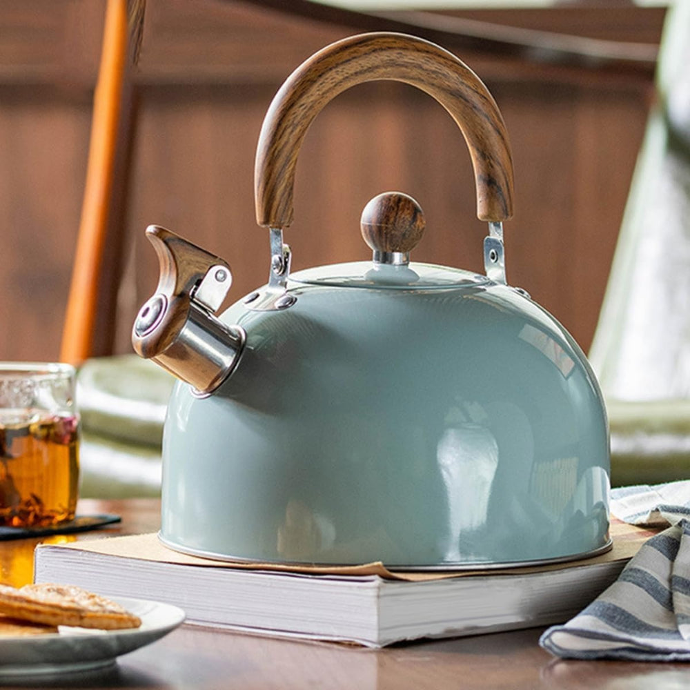 Light blue kettle with wooden handle on a wooden surface