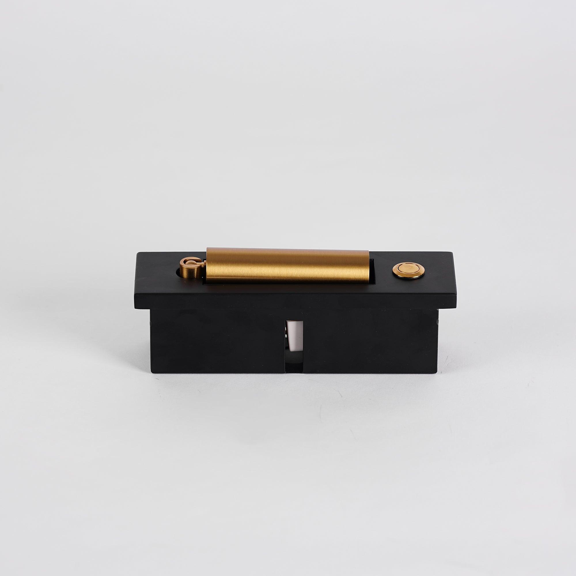 Black and gold mechanical device on a light gray background